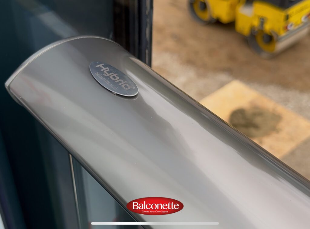 Royal Chrome handrail and clear glass panels of a Hybrid Aerofoil glass balustrade on a completed roof terrace